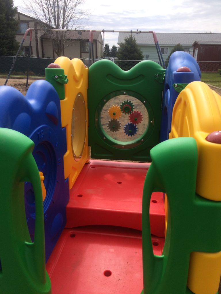 Inside of play equipment showing off multi-colored pieces and cogs