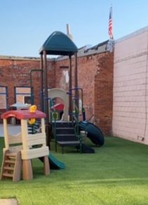 Updated outdoor play space with new artificial turf and commercial playground structure